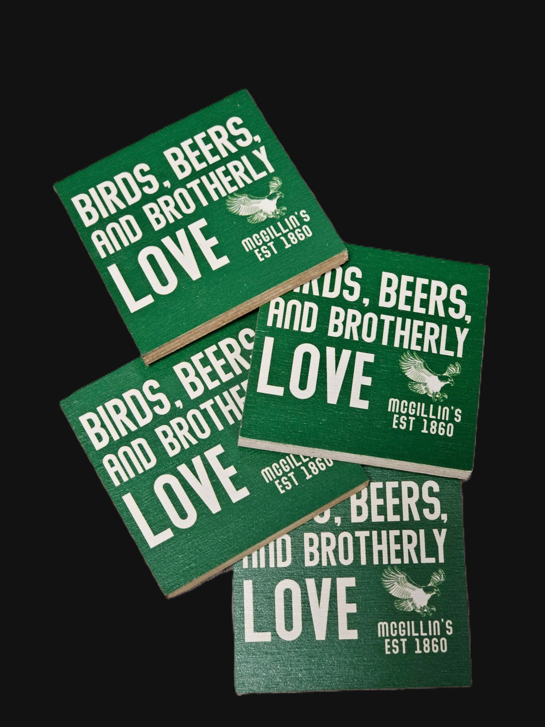 Green coasters with text and a logo on a black background