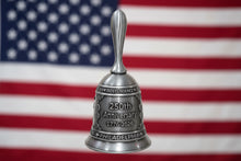 Silver bell with '250th Anniversary 1776-2026 Philadelphia' text on a beige background